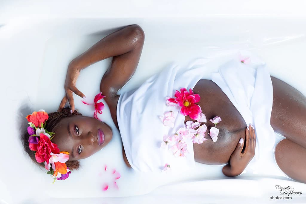 Portrait de grossesse dans un bain de lait fleuri