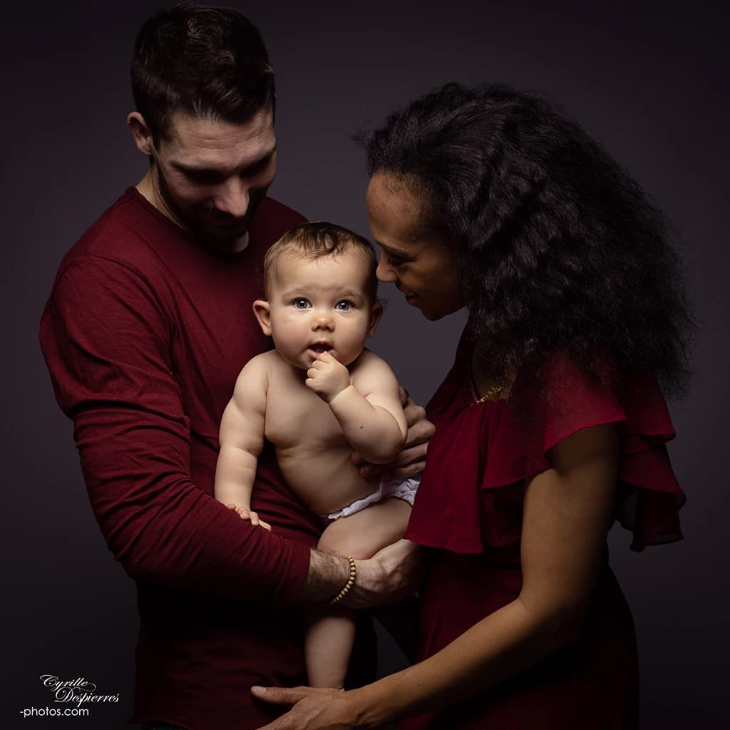 Deux parents entourant leur bébé en studio